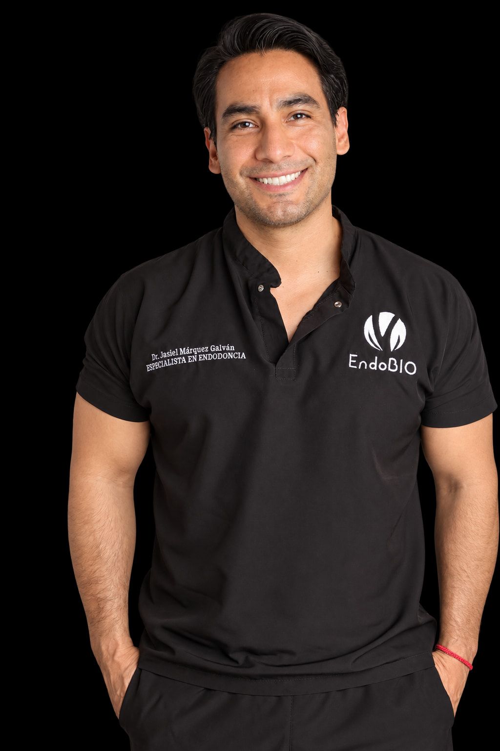 El Dr. Jasiel Márquez Galván sonríe con su uniforme negro de EndoBIO, bordado con su nombre y la leyenda Especialista en Endodoncia